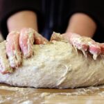 Immagine di un impasto di pane in una ciotola, coperto da un panno per il riposo.