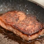 Carne alla griglia con una crosticina dorata e croccante, pronta per essere servita.