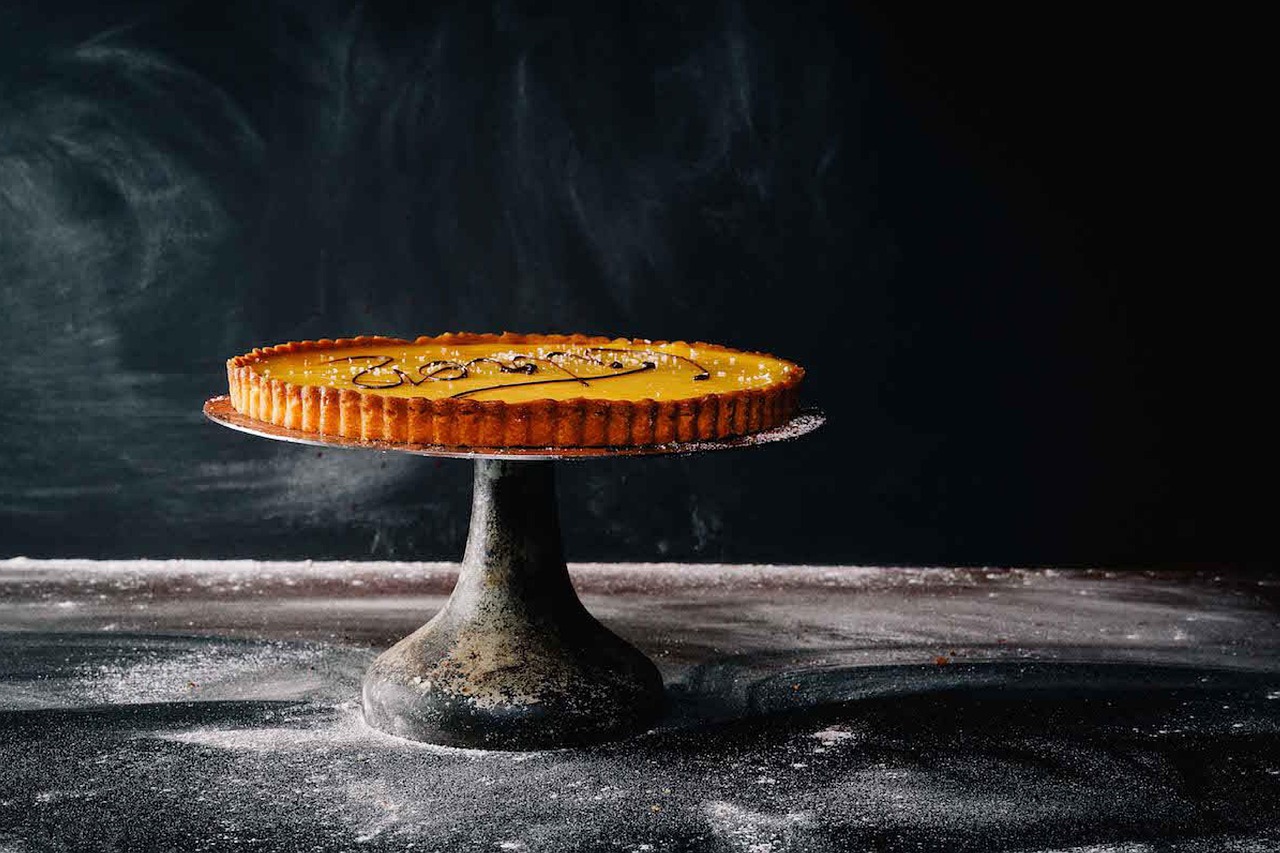Crostata morbida appena sfornata, con una morbida crema e frutta fresca decorativa.